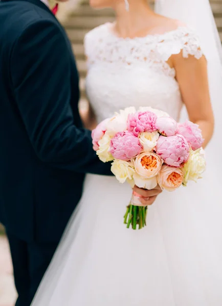 Wedding roses and peonies in the hands of the bride. Wedding in — Stock Photo, Image