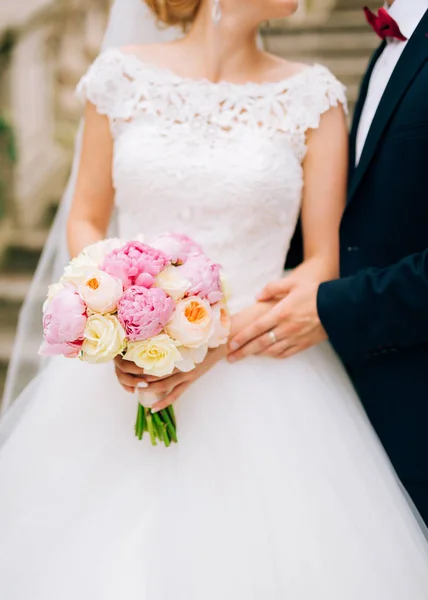 Brautrosen und Pfingstrosen in den Händen der Braut. Hochzeit in — Stockfoto
