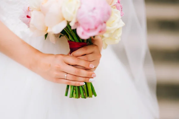 Wedding roses and peonies in the hands of the bride. Wedding in