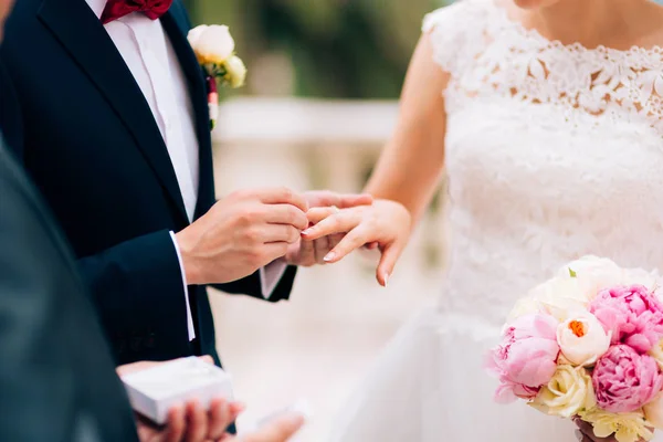 The groom dresses a ring on the finger of the bride at a wedding