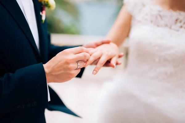 The groom dresses a ring on the finger of the bride at a wedding