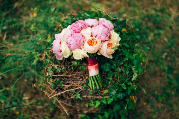 Wedding roses and peonies on a stump with ivy. Wedding in Monten