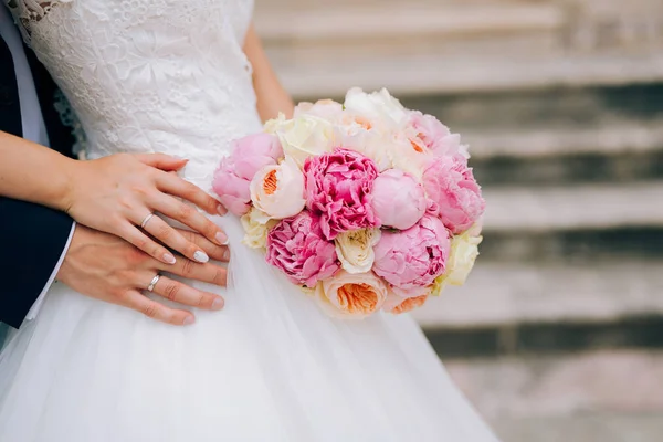 Wedding roses and peonies in the hands of the bride. Wedding in