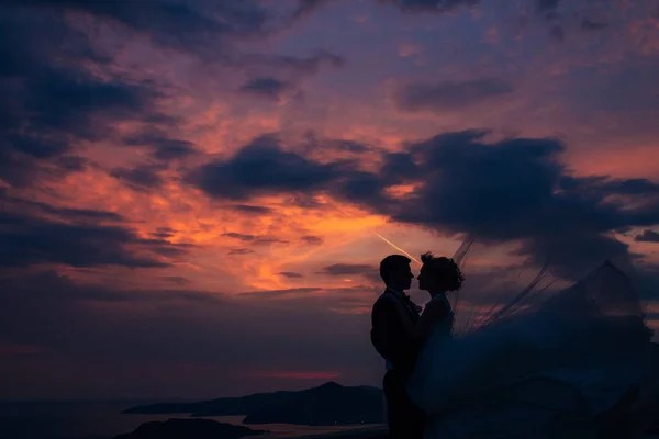 Silhouette des Brautpaares gegen den Himmel bei Sonnenuntergang. Hochzeit i — Stockfoto