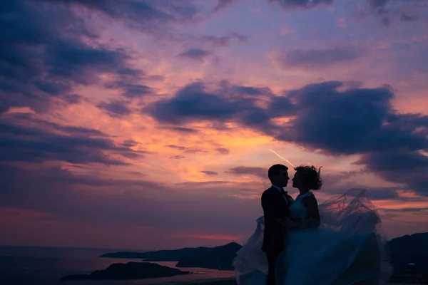 Silhouette des jeunes mariés contre le ciel au coucher du soleil. Mariage i — Photo