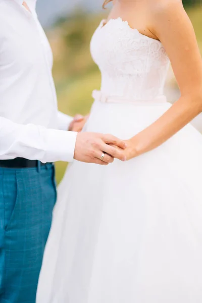 Os recém-casados dão as mãos. Um casal de mãos dadas. Casamento em Monte — Fotografia de Stock