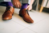 A férfi szürke nadrág és egy lila ruhát barna cipő, zokni
