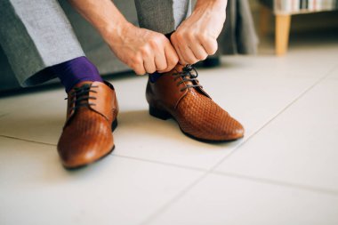 Adam gri pantolon ve mor bir elbise ile kahverengi ayakkabı çorap