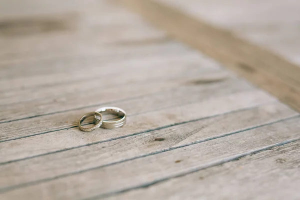 Anneaux de mariage sur une texture en bois léger — Photo