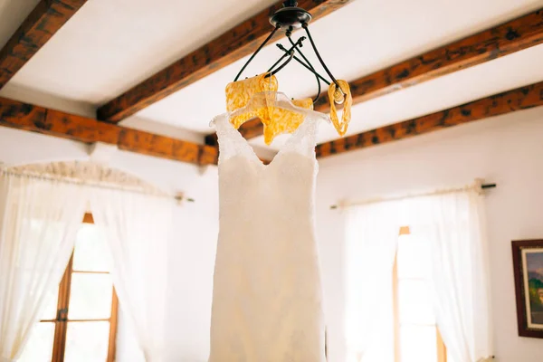 Vestido de novia novia está colgando de la lámpara de araña —  Fotos de Stock