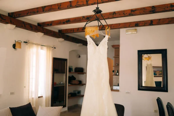 Vestido de novia novia está colgando de la lámpara de araña —  Fotos de Stock