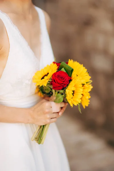 Buquê de casamento de girassóis nas mãos da noiva . — Fotografia de Stock