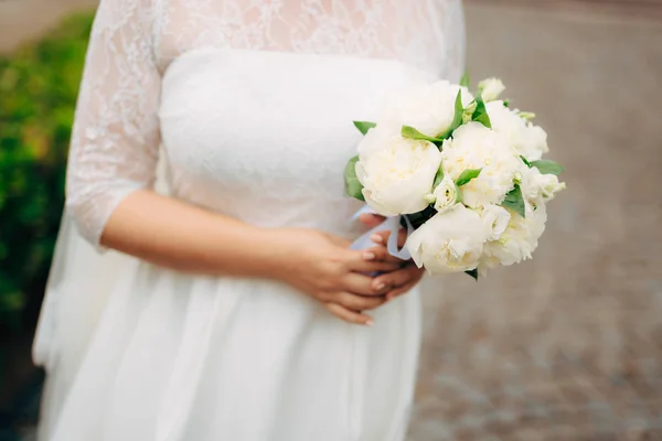 Wedding roses and peonies in the hands of the bride. Wedding in