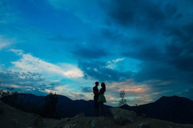 Yeni evliler günbatımı gökyüzüne karşı silüeti. Ben düğün