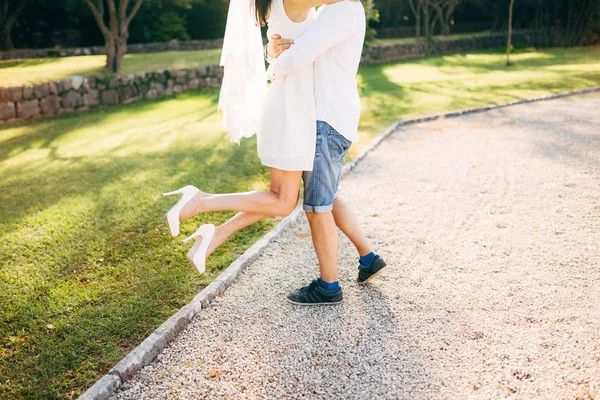 Hob der Bräutigam die Braut in den Arm. Beine aus nächster Nähe. Hochzeit i — Stockfoto