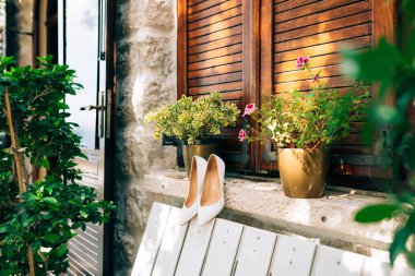 Beyaz bir Bank ve backgrou çiçekler beyaz gelin ayakkabıları