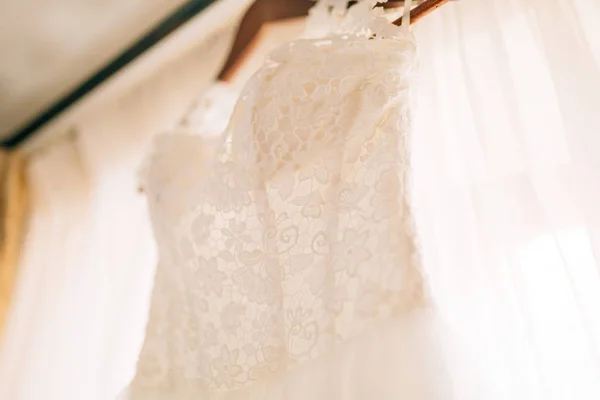 Il vestito da sposa pende sulla cornice — Foto Stock