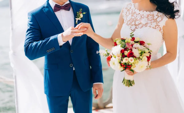 A noiva coloca o anel no noivo no cerimonial de casamento. — Fotografia de Stock
