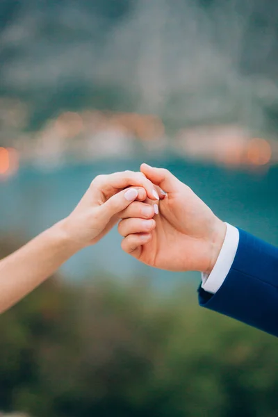 Os recém-casados dão as mãos. Um casal de mãos dadas. Casamento em Monte — Fotografia de Stock