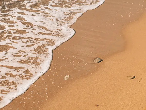 Zandstrand en golven, close-up. Het patroon van zand en water. PICT — Stockfoto