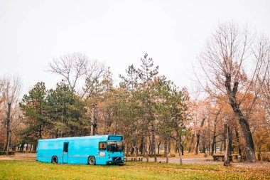 Sonbahar parkında mavi otobüs