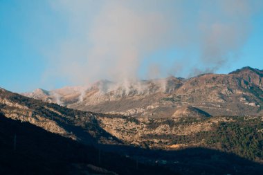 Dağlarda öğleden sonra ateş. Dağları duman