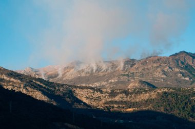 Dağlarda öğleden sonra ateş. Dağları duman