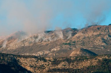 Dağlarda öğleden sonra ateş. Dağları duman