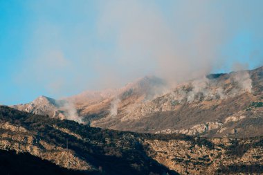 Dağlarda öğleden sonra ateş. Dağları duman