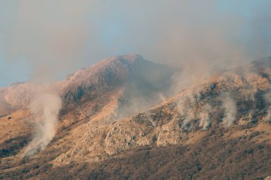 Dağlarda öğleden sonra ateş. Dağları duman