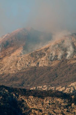 Dağlarda öğleden sonra ateş. Dağları duman