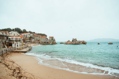 Przno, Karadağ. Plaj, şezlong ve şemsiyeleri sahilde, t