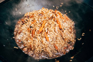 Kazan içinde Plov yemek. Pirinç, et, soğan ve havuç içinde