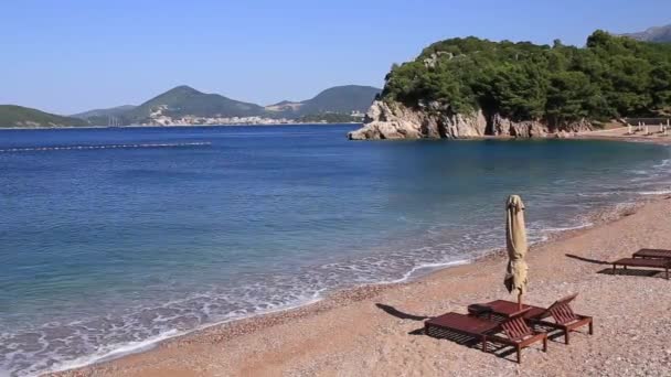 Solstolar och parasoller på stranden. Montenegrinska stränderna i den — Stockvideo