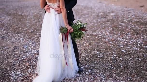 新郎は、ビーチで花嫁を取り入れています。モンテネグロでの結婚式 — ストック動画