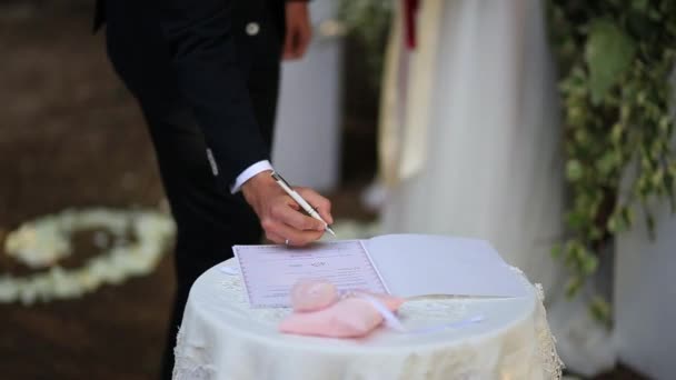 Brudgummen sätter signaturen på bröllopet. — Stockvideo