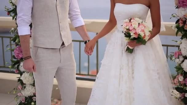 Los recién casados se toman de la mano en la ceremonia de boda. Pareja sosteniendo — Vídeo de stock