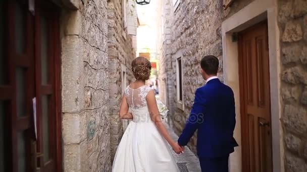 Couple holding hands in the old city. A newly married couple in — Stock Video