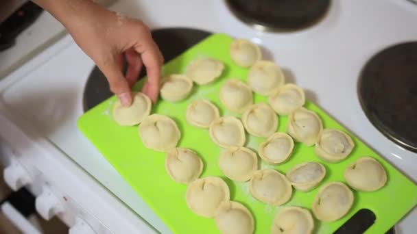She sculpts dumplings in the kitchen. Cooking food. — Stock Video