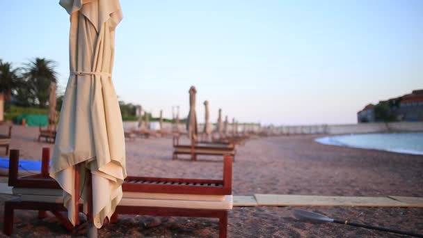 Sun beds and umbrellas on the beach. Montenegrin beaches of the — Stock Video