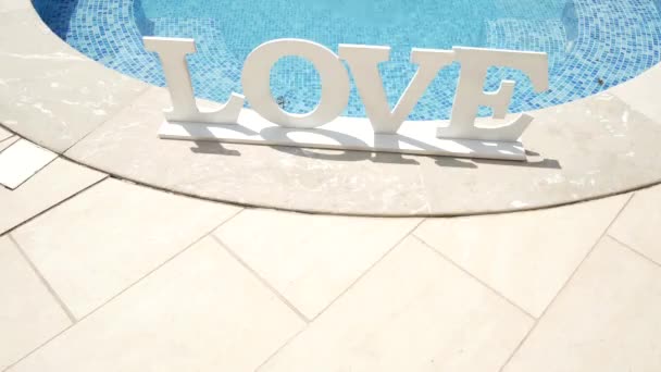 La inscripción "Amor" del árbol cerca de la piscina — Vídeo de stock