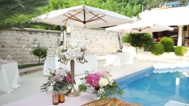 Una mesa en el banquete de bodas cerca de la piscina. Decoración de boda — Vídeos de Stock