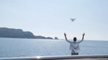 Bir adam denizde bir yatta bir dron başlattı. Bir dron sinekler üzerinden uçuyor