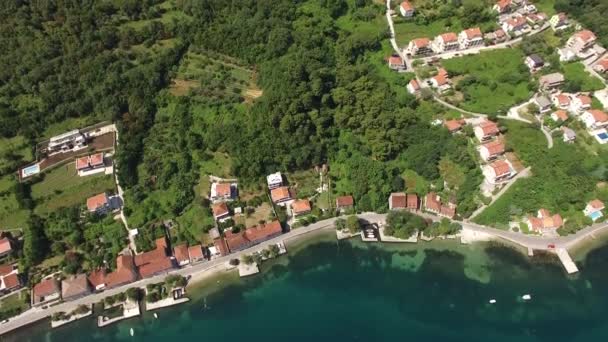Staden sandig strand med en brygga och kustnära bostad hus i staden Petrovac. Flygfoto — Stockvideo