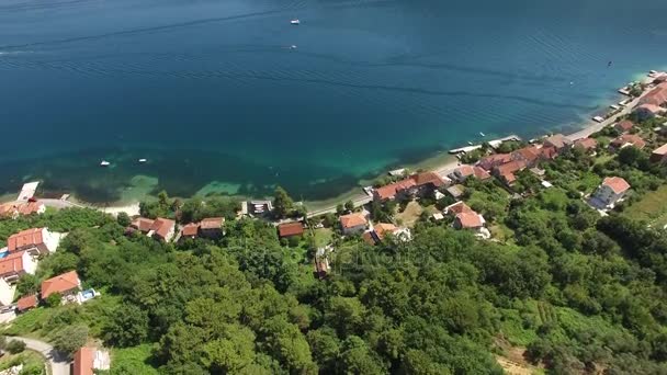 Stad zandstrand strand met een pier en kust woning huizen in de stad van Petrovac. Luchtfoto — Stockvideo