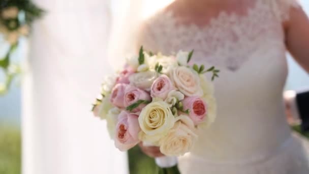 Bruiloft rozen en pioenrozen in de handen van de bruid. Bruiloft in — Stockvideo