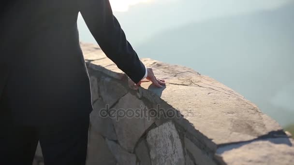 Händerna på brudgummen på en sten gränsen — Stockvideo