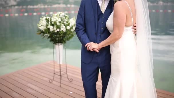 Los recién casados se dan la mano en el mar. Pareja cogida de la mano. Boda i — Vídeo de stock