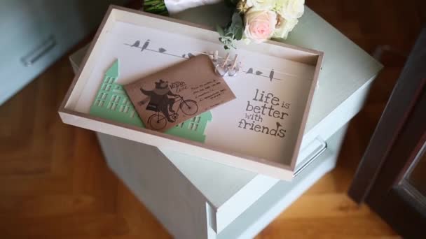 Anéis de casamento em um envelope com uma carta com um buque de casamento — Vídeo de Stock