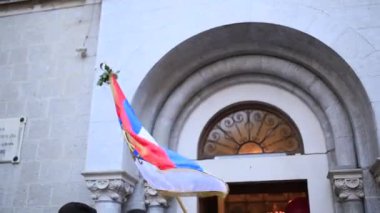 Kotor kilisede önünde sallayarak Sırbistan bayrağı
